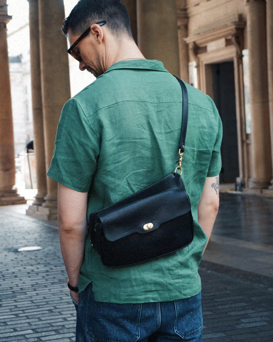 Black leather crossbosy bag with clasp and zip, won on the back.